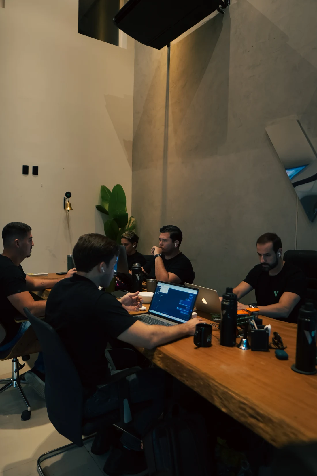 Equipe da Valle trabalhando em uma mesa de madeira com notebooks